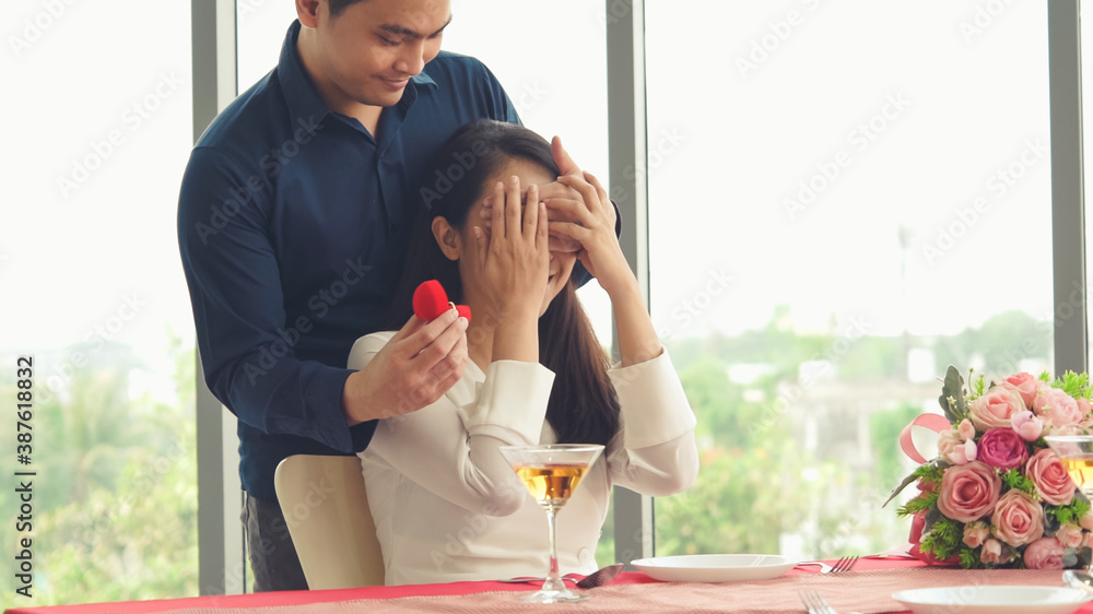 Romantic couple giving gift to lover at restaurant . Happy couple lifestyle .