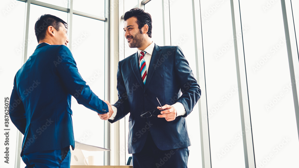 Business people handshake in corporate office showing professional agreement on a financial deal con