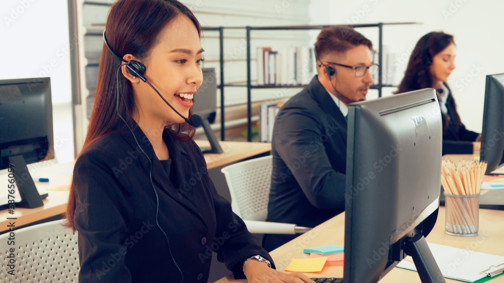 Business people wearing headset working in office to support remote customer or colleague. Call cent