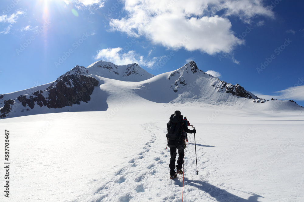 Rope team mountaineering with crampons on glacier Taschachferner towards Wildspitze and mountain sno