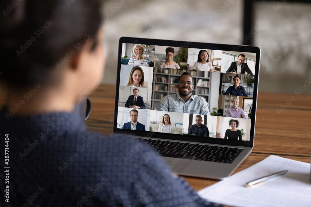 Over shoulder view of female worker have webcam digital virtual conference with diverse multiethnic 