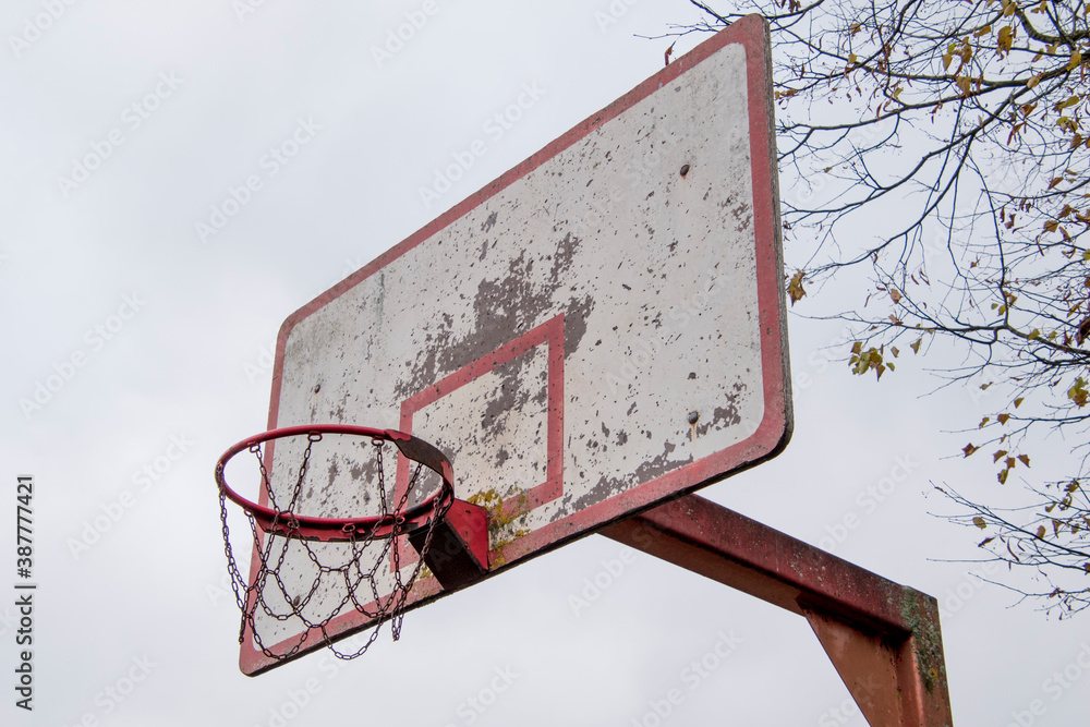 Old damaged basketball shield with chipped paint and board.