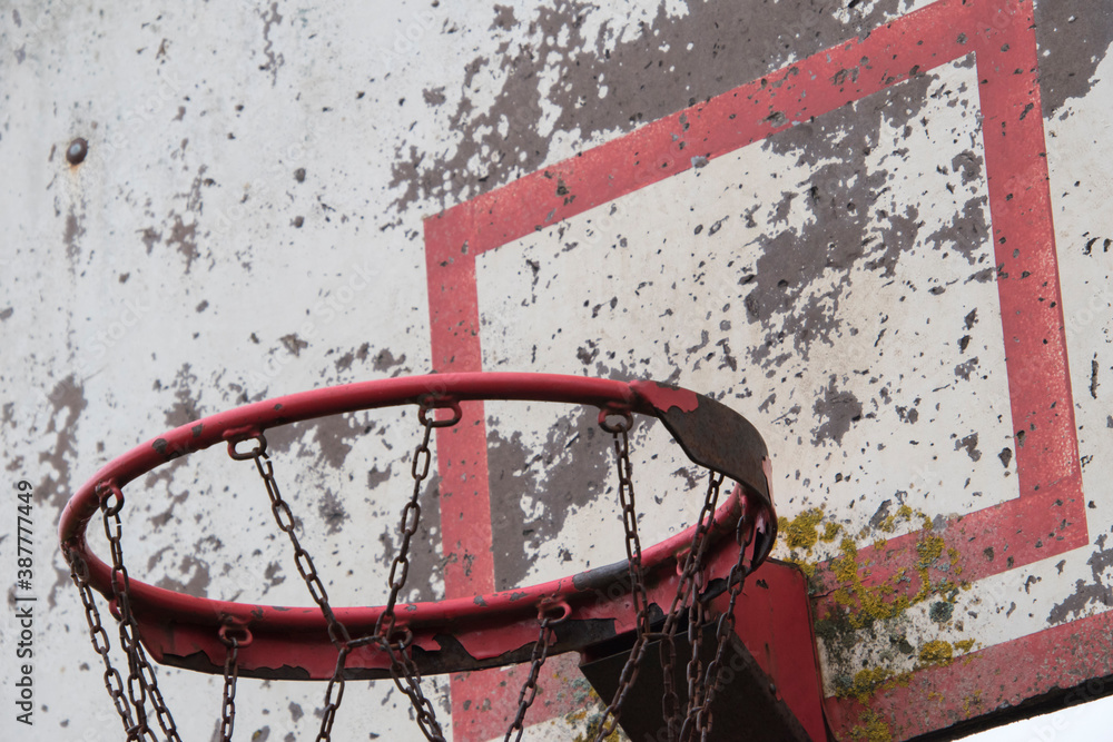 Old damaged basketball shield with chipped paint and board.