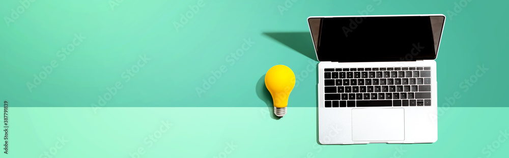 Laptop computer with a yellow light bulb from above