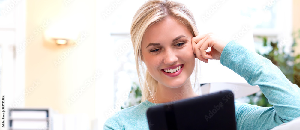 Young woman using her tablet computer at home