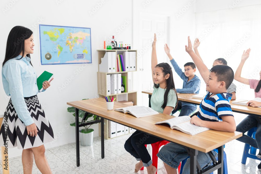 asian students studying with teacher in classroom, asian teacher stand and use hand holding a book, 