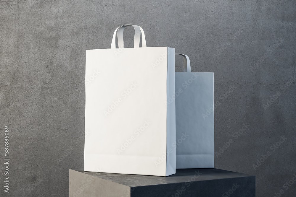 Two white paper bag with handles on podium.