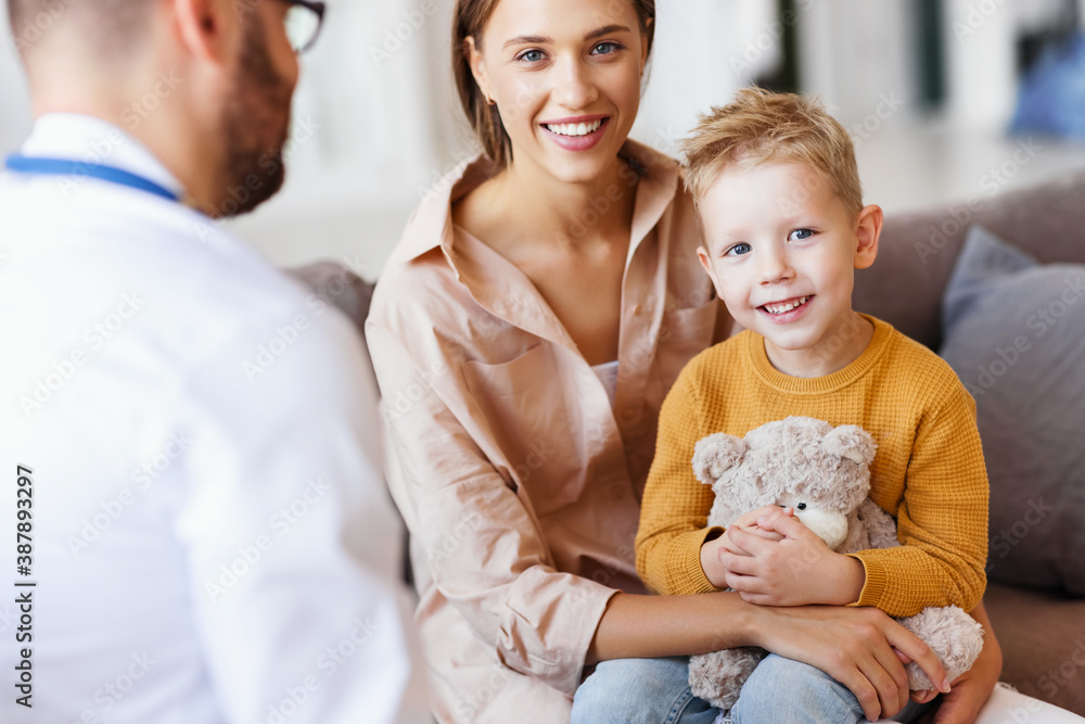 happy child boy patient with his mother at reception of a friendly pediatrician family doctor family