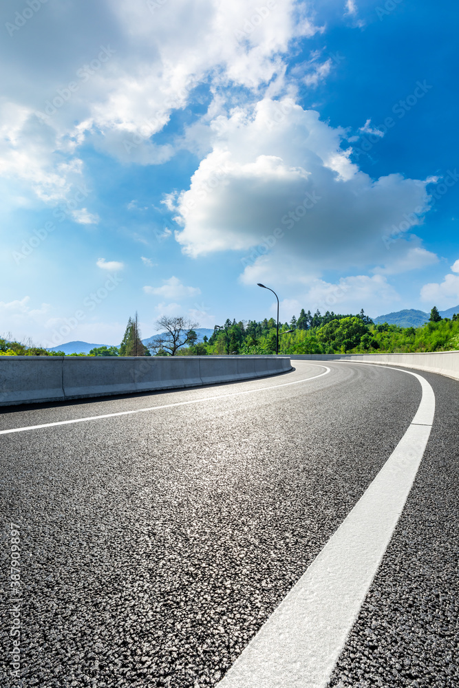 Asphalt road and green mountain natural scenery in Hangzhou on a sunny day.