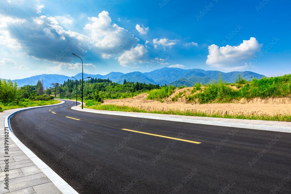 Asphalt road and green mountain natural scenery in Hangzhou on a sunny day.