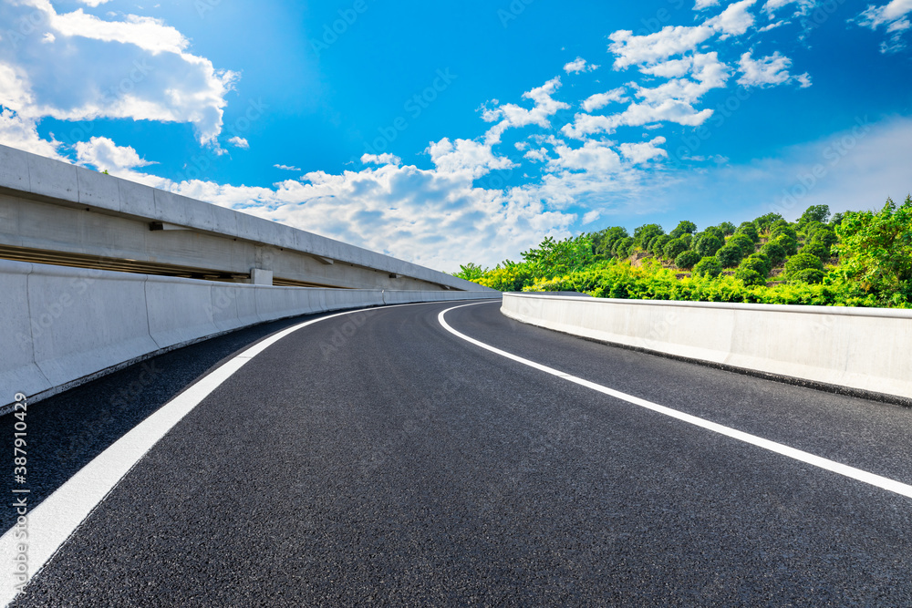 Asphalt road and green tea plantations with mountain natural scenery in Hangzhou on a sunny day.