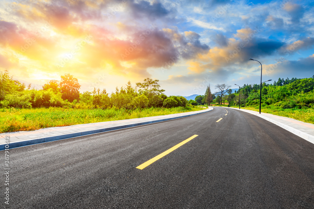 Countryside asphalt road and green plants with mountain natural scenery in Hangzhou at sunrise.