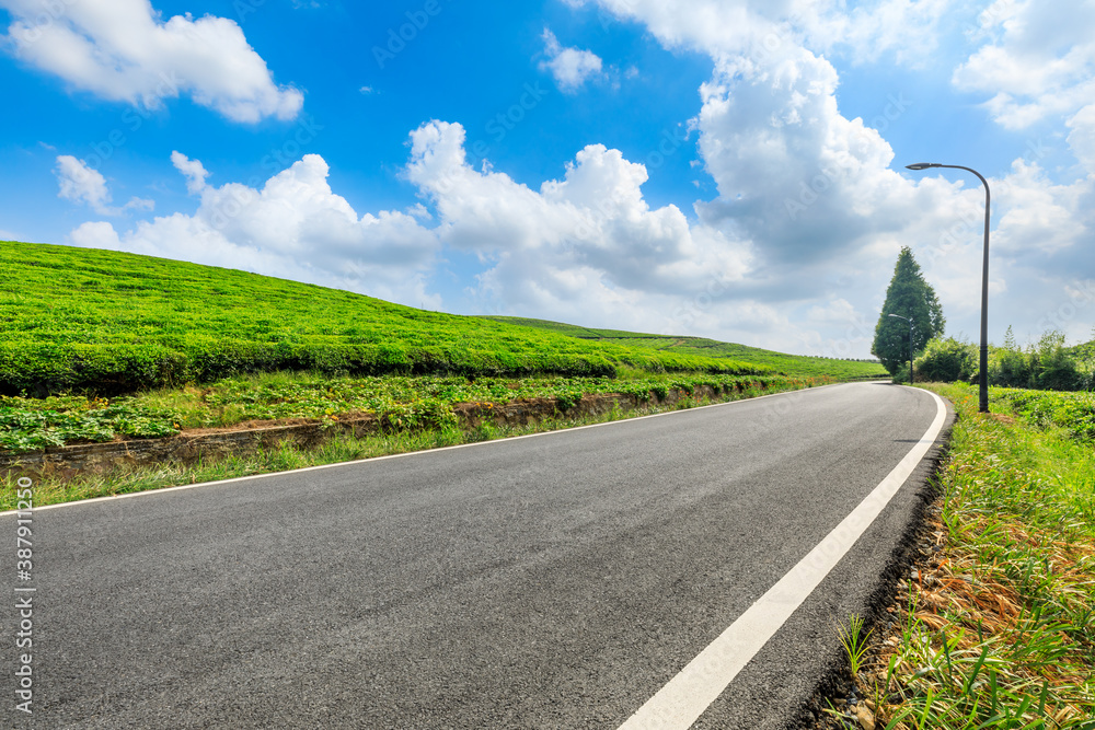 Countryside asphalt road and green tea plantations with mountain natural scenery in Hangzhou on a su