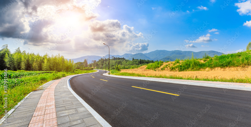 Countryside asphalt road and green plants with mountain natural scenery in Hangzhou on a sunny day.