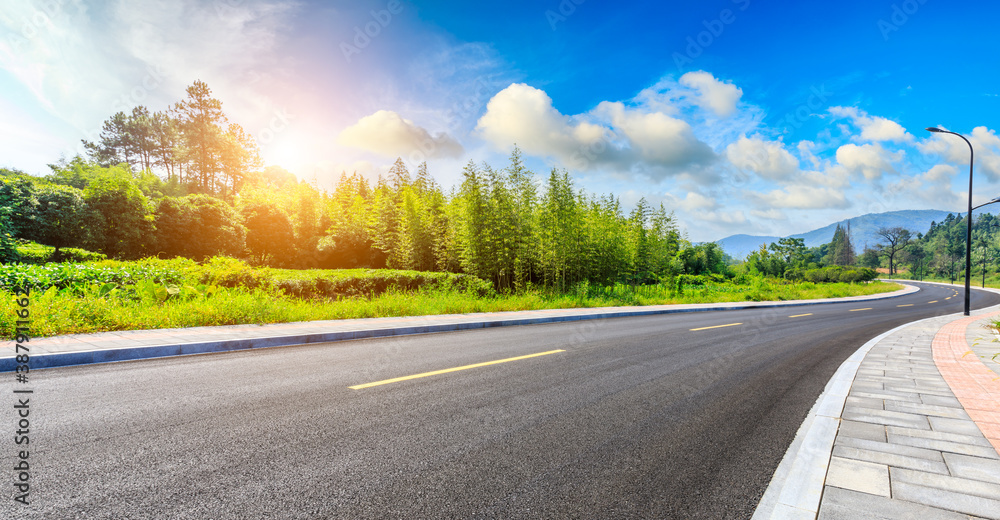 Countryside asphalt road and green plants with mountain natural scenery in Hangzhou on a sunny day.