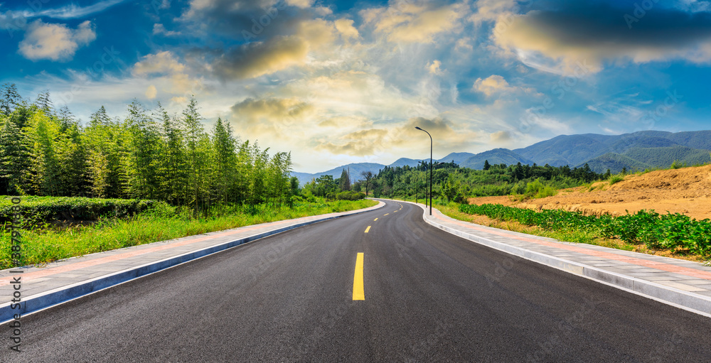 Countryside asphalt road and green plants with mountain natural scenery in Hangzhou on a sunny day.