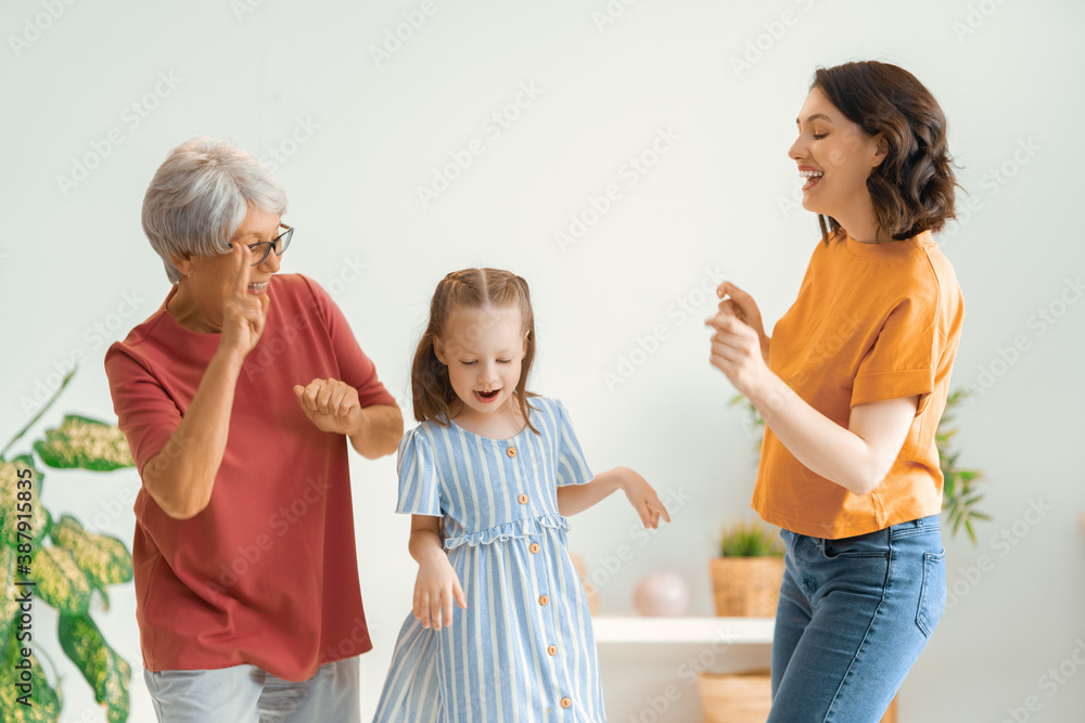 Grandmother, mother and daughter are dancing