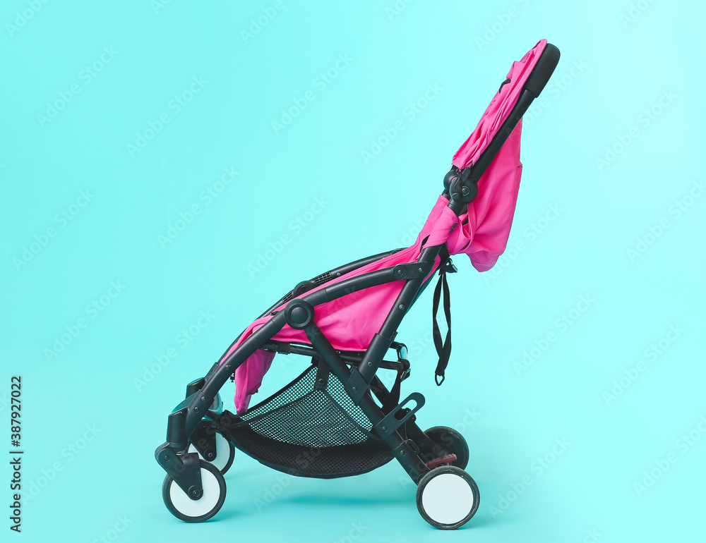 Modern baby stroller on color background