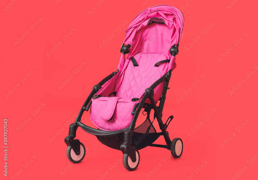 Modern baby stroller on color background