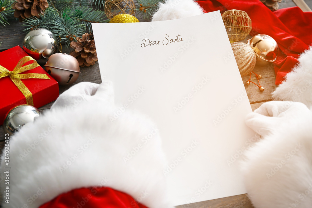 Santa with letter and Christmas decor on wooden background