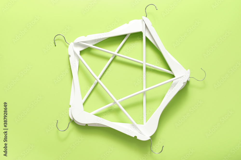 Composition with clothes hangers on color background