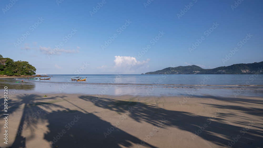 Patong beach in the morning with shadow coconut palm trees on sand beach at Phuket Thailand.