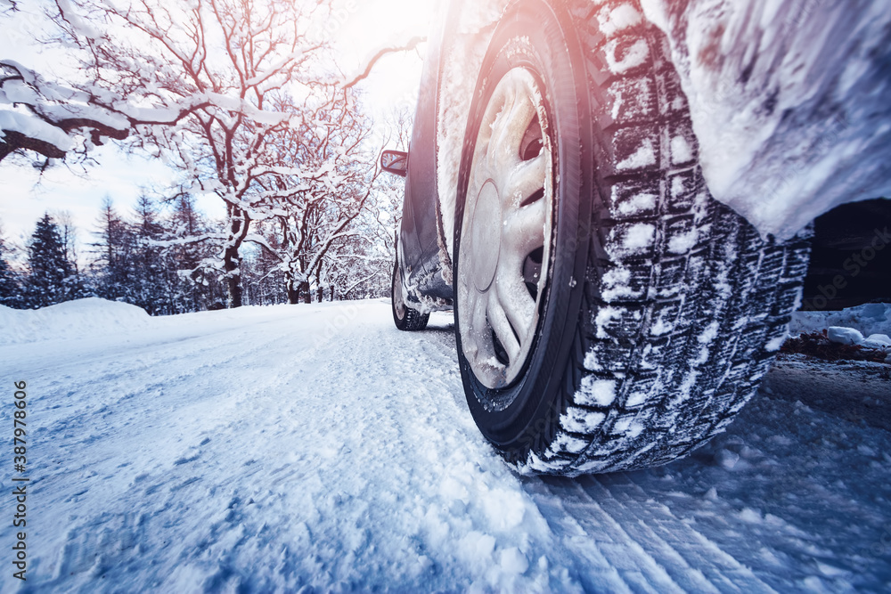 汽车轮胎在被雪覆盖的冬季道路上行驶