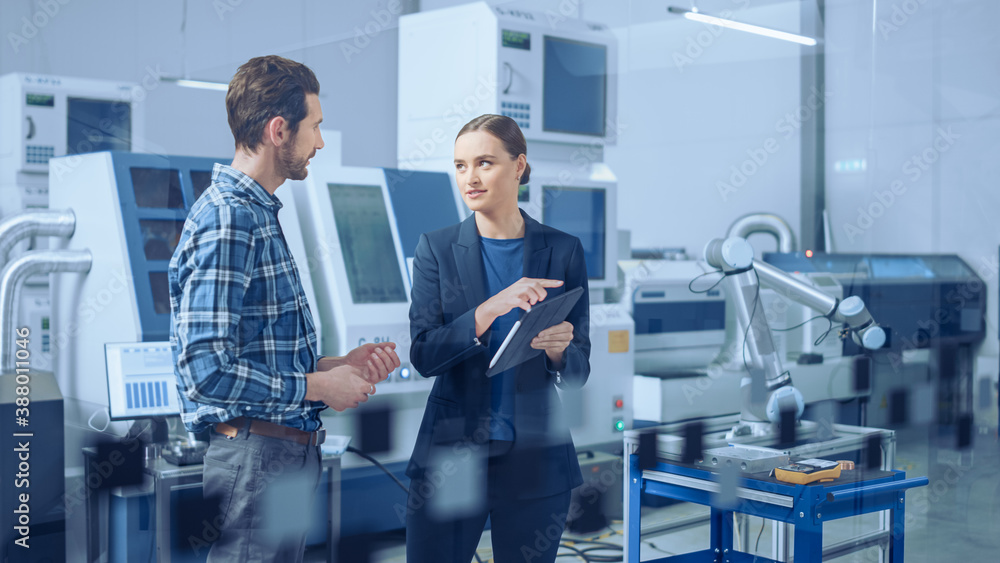 Modern Factory: Female Project Manager and Male Engineer Standing, Talking, Using Digital Tablet for