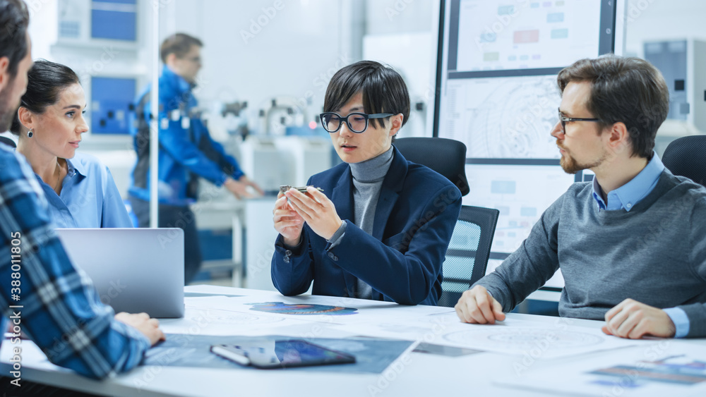 Factory Office Meeting Room: Computer Design Specialist Holds Printed Circuit Board Prototype and Re