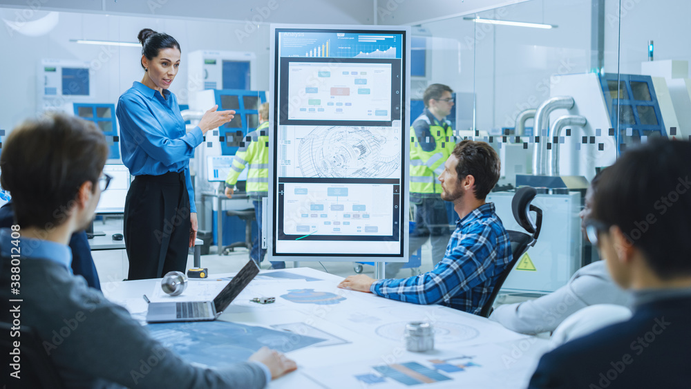 On a Meeting: Confident Female Engineer Talks to a Group of Specialists, Managers, Uses Interactive 