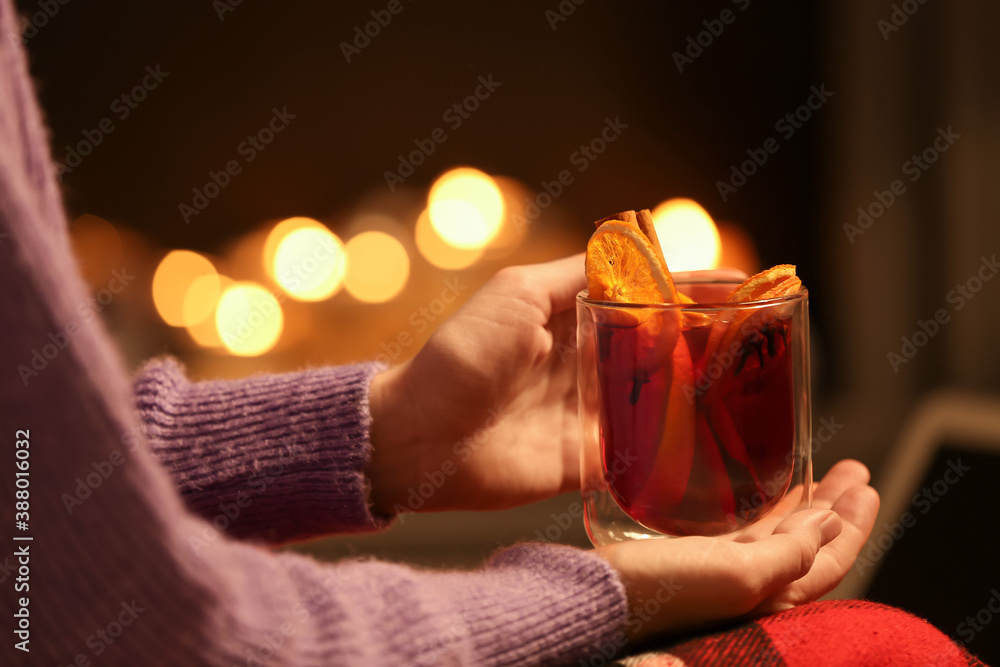 Woman drinking mulled wine at home in evening