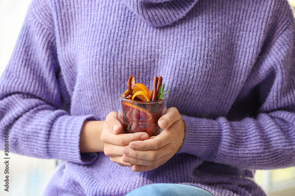 Woman drinking mulled wine at home, closeup