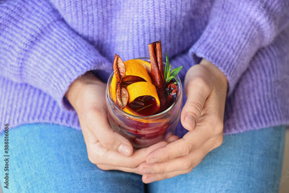 Woman drinking mulled wine at home, closeup