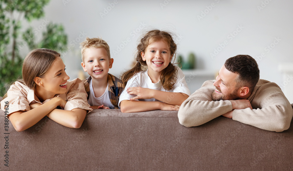 happy family mother father and children at home on couch .