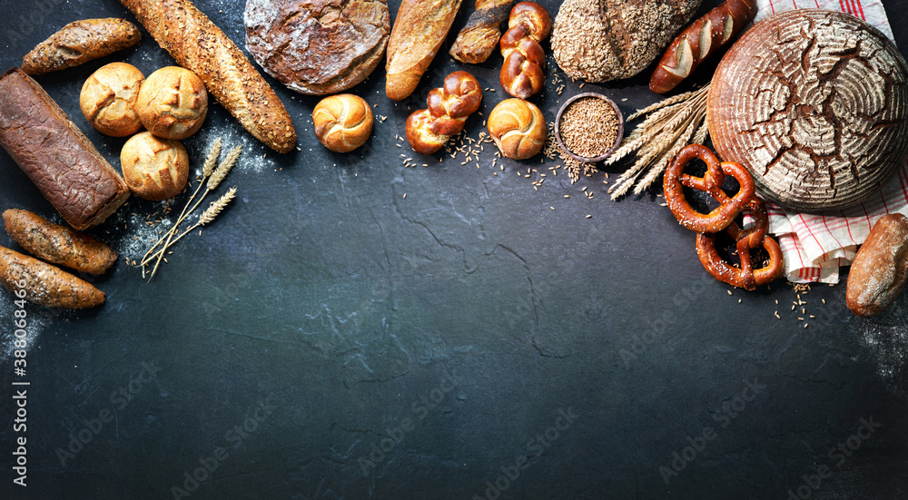 Delicious freshly baked bread assortment on dark rustic background