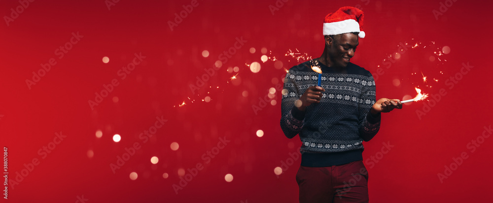 African man with wishing merry Christmas with sparklers