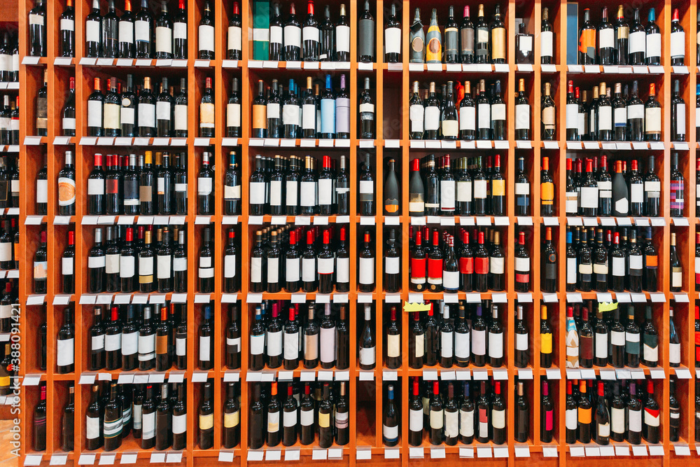 Showcase With Wine Bottles At The Wine Store. Wall With Alcoholic Drinks Wine Bottles On Shelves