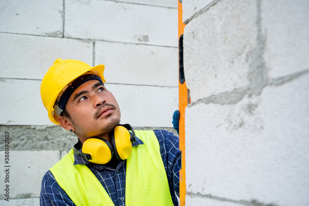 Construction worker measures level wall at window In the house under construction,Level is used to i