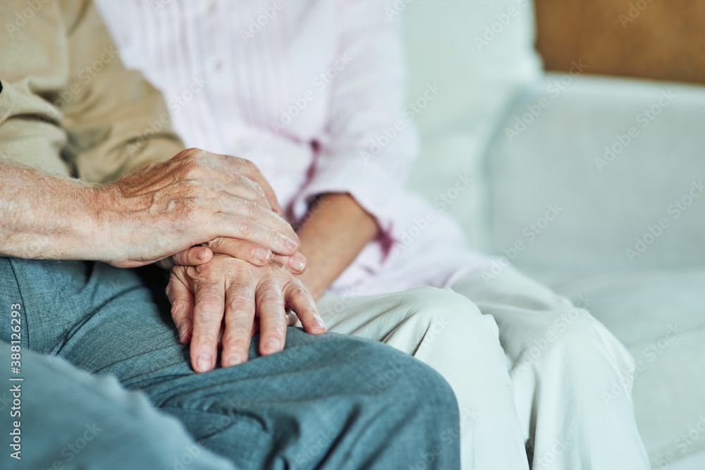 Cropped photo of elderly man holding hands of his wife