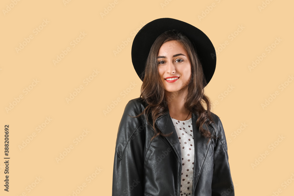 Stylish young woman in autumn clothes on color background