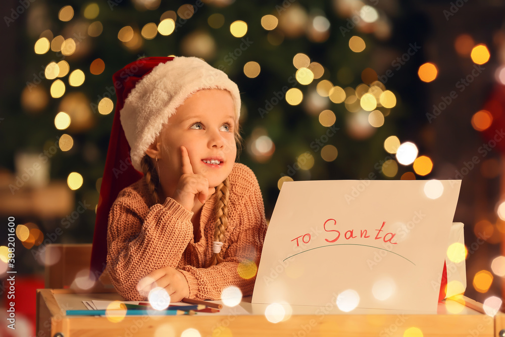 Cute little girl writing letter to Santa at home