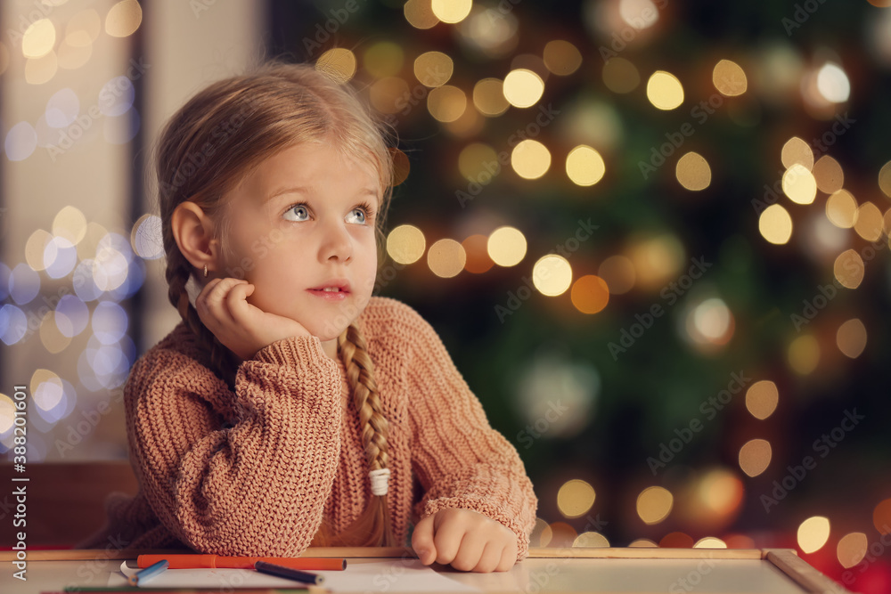 Cute little girl writing letter to Santa at home