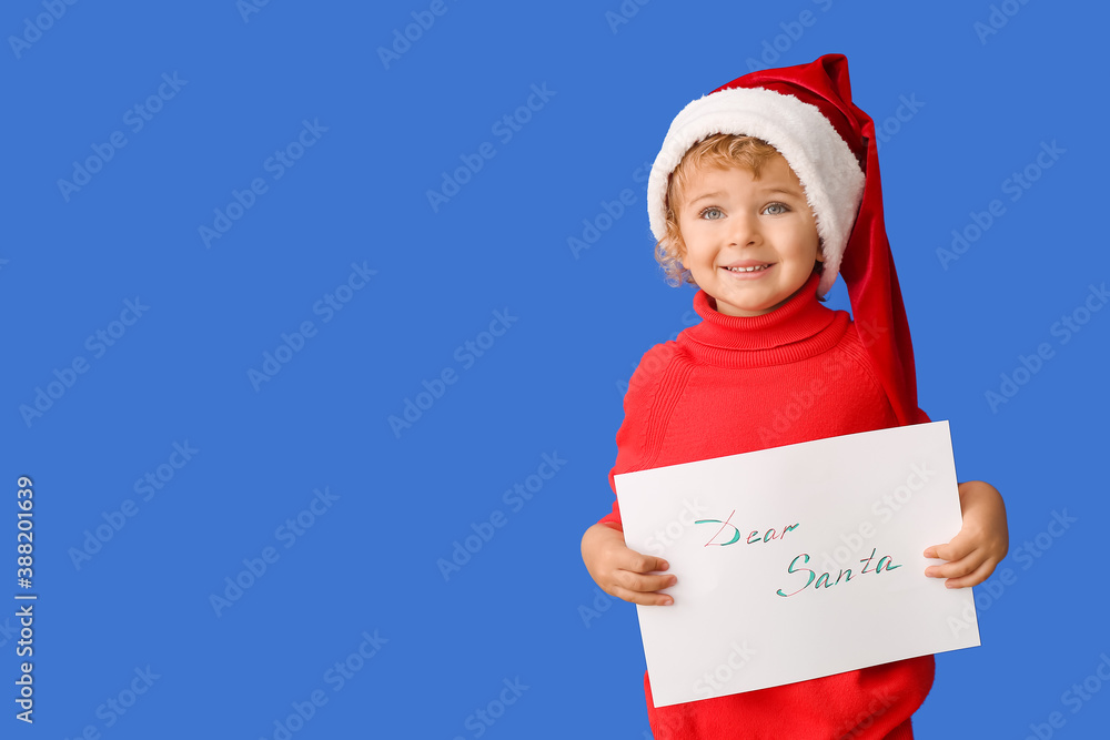 Cute little child with letter to Santa on color background