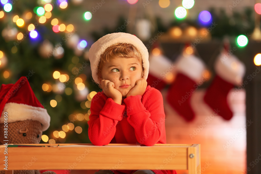 Cute little child writing letter to Santa at home