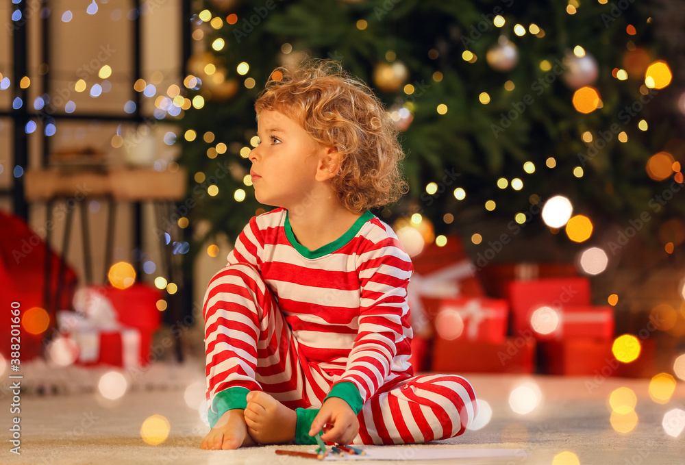 Cute little child writing letter to Santa at home