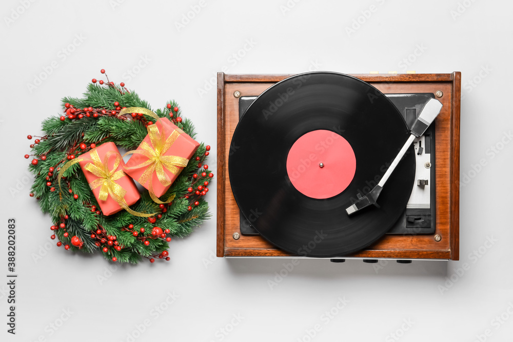 Record player and Christmas decor on light background