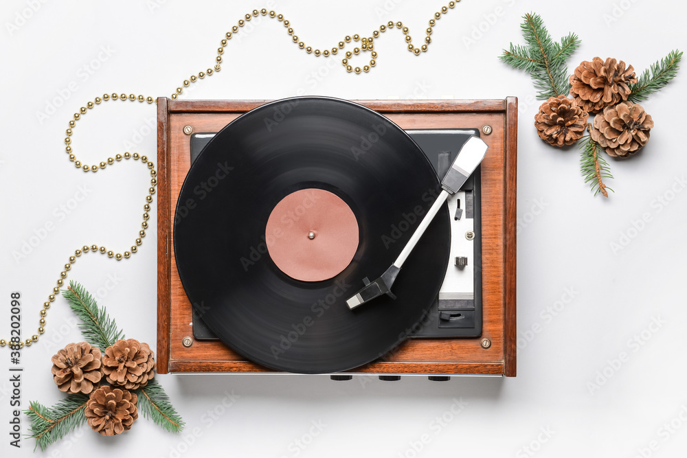 Record player and Christmas decor on light background