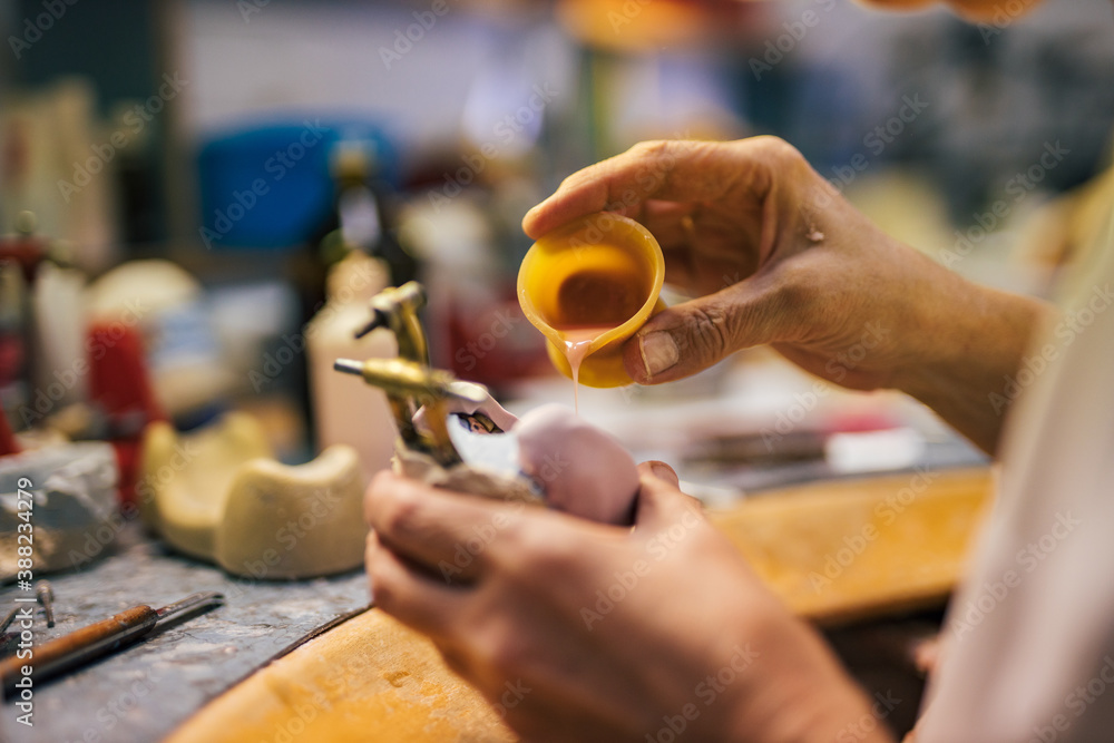 Dental technician molding dental prosthetic model.