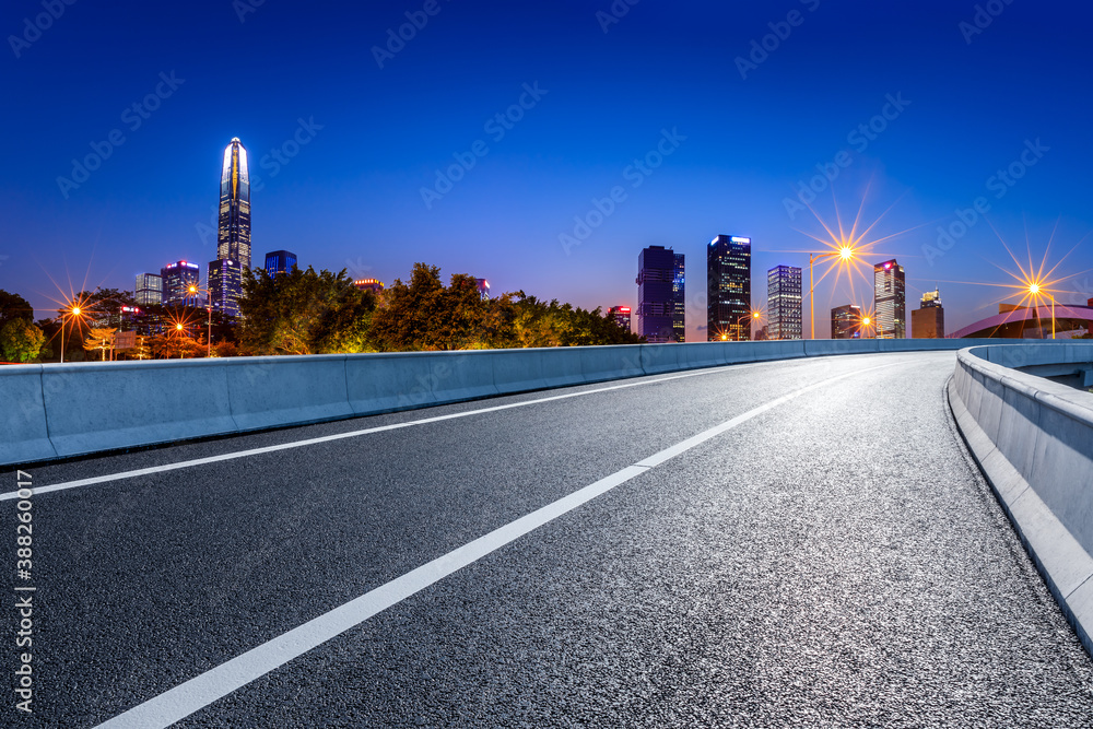 Asphalt highway and urban commercial building scenery in Shenzhen at night.