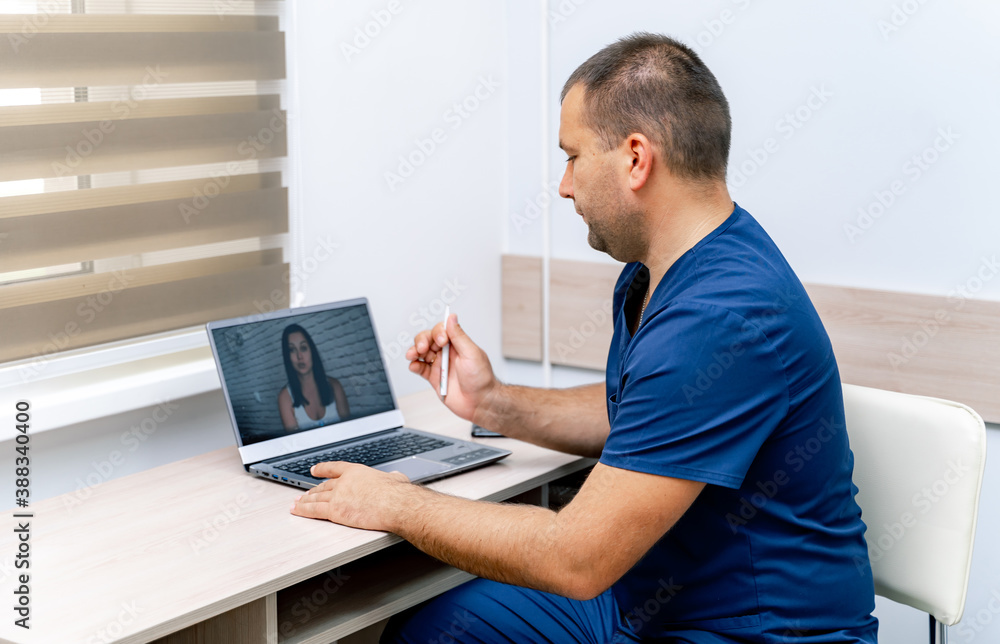 Online consultation in office. Medic has video call with patient. Modern clinic background.